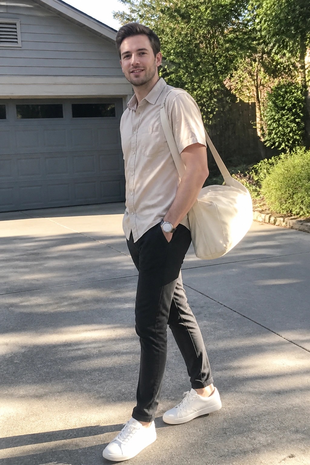 Man in beige shirt and black pants with tote bag on driveway