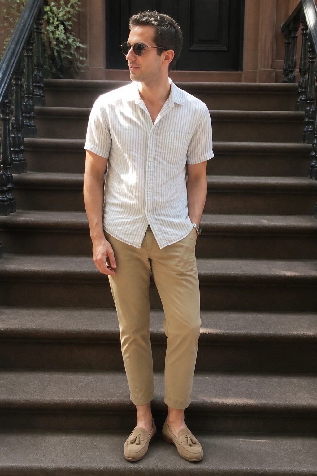 Man in striped shirt and khaki pants with tassel loafers on stone steps