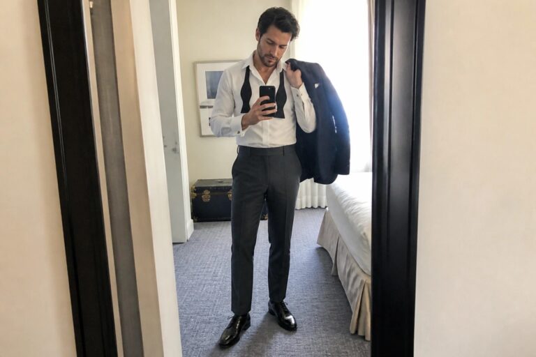 25 Wedding Trousers for Men Styled for Sophisticated Formal Celebrations Man in white shirt taking mirror selfie with untied black bow tie and jacket