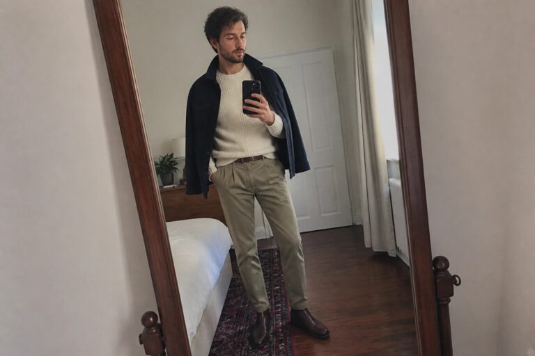 18 Timeless Fall Khaki Outfit Ideas for Men Featuring Knitwear, Jackets, and Neutral Tones Man in cream sweater, navy jacket, khaki pants, and brown boots taking mirror selfie.