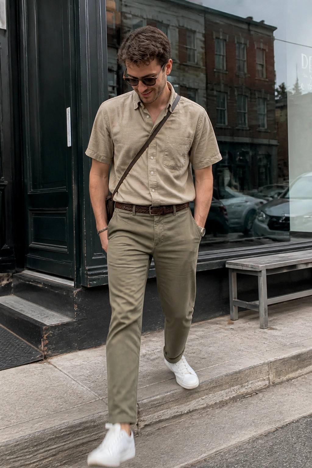 Man in beige shirt and olive pants with white sneakers on urban steps
