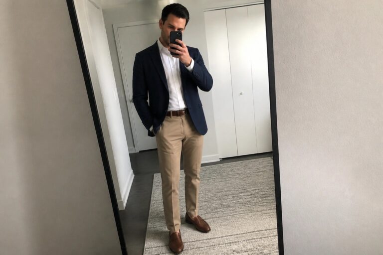 19 Sharp Office Outfits for Men Using Chinos Instead of Traditional Dress Pants Man in navy blazer, white shirt, and khaki pants taking mirror selfie