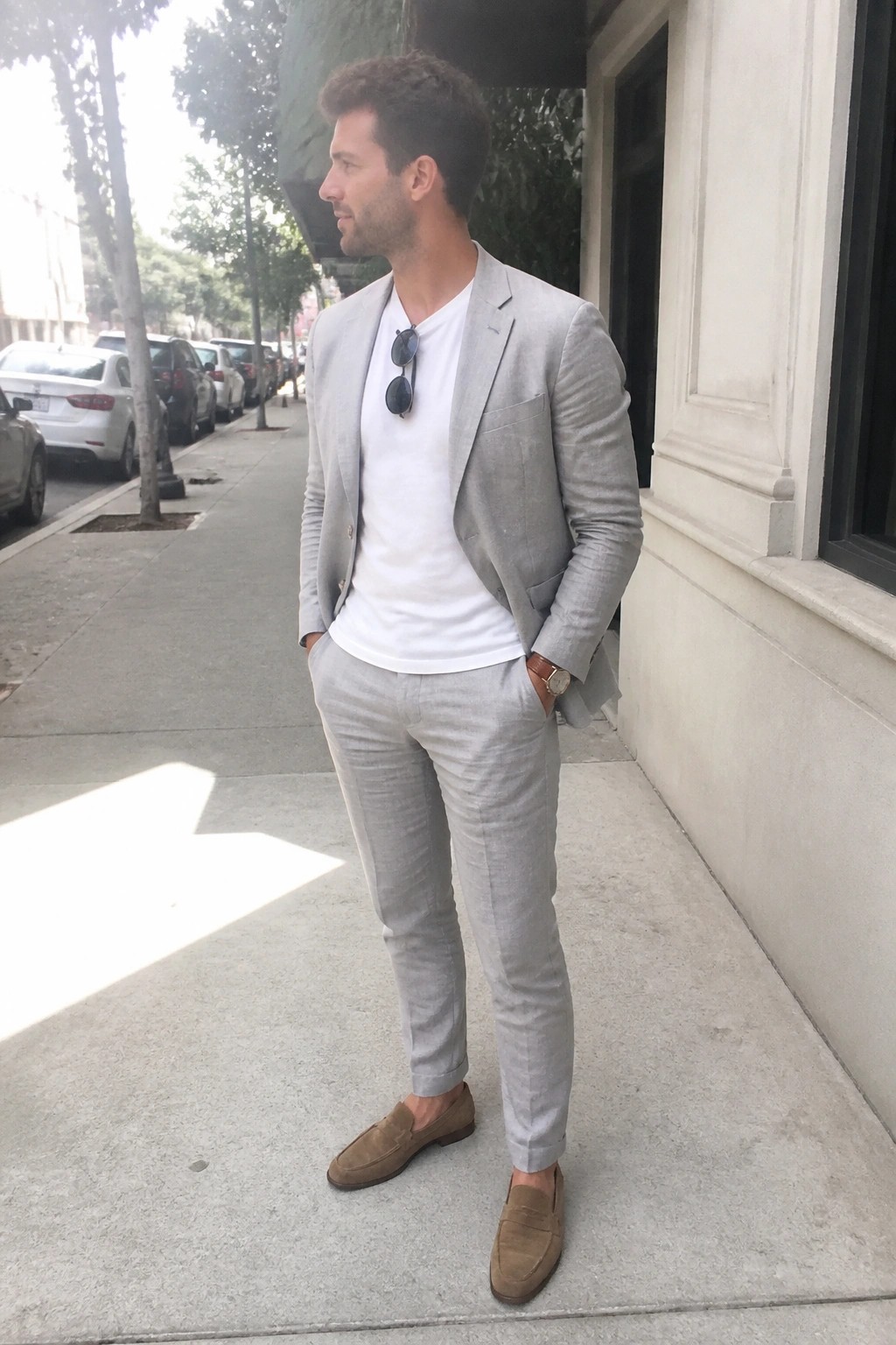 Man in light gray suit with white t-shirt and brown suede loafers on sidewalk