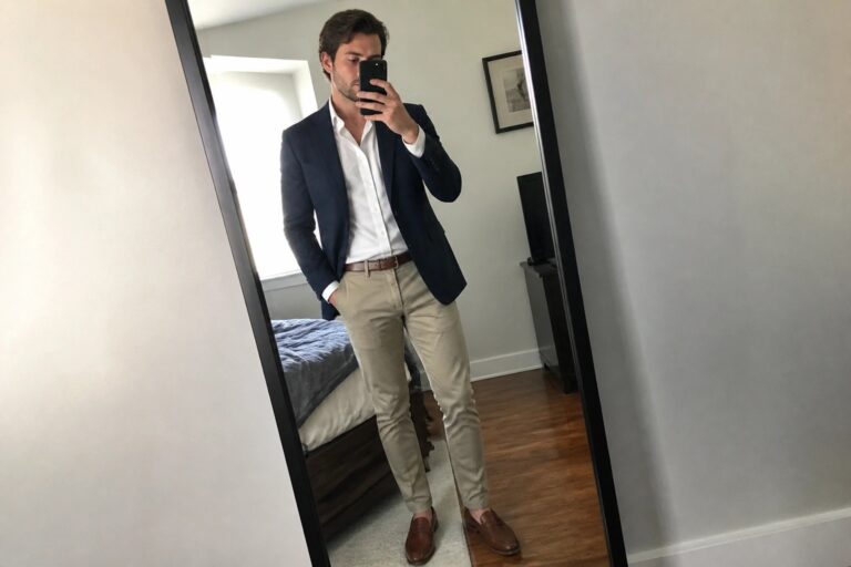 22 Versatile Khaki Trouser Outfits for Men That Meet Corporate Dress Codes Man in navy blazer, white shirt, and khakis taking bedroom mirror selfie