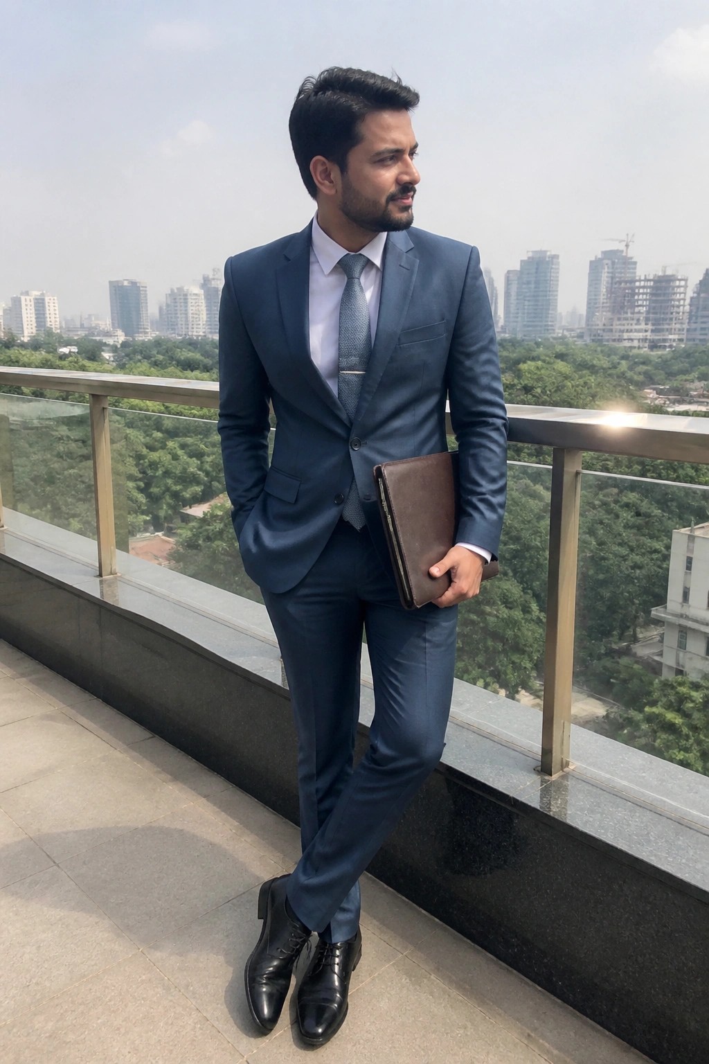 Man in blue suit holding brown leather folder on city balcony