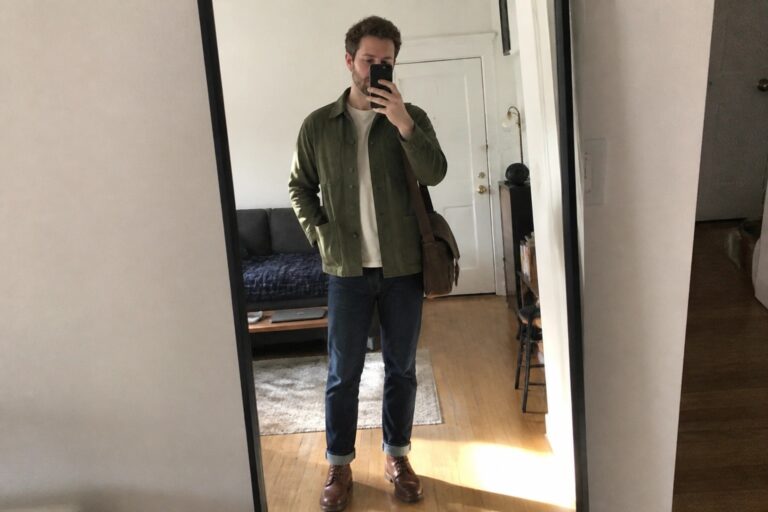 20 Creative Men’s Fall Casual Outfits Built Around Chore Coats Man in green jacket over white tee with jeans and boots taking mirror selfie