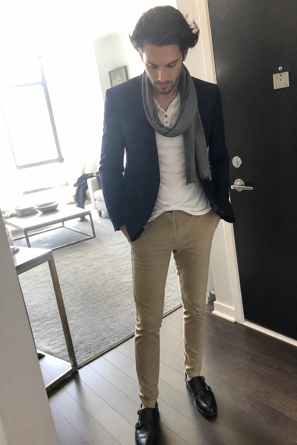 Man in navy blazer, white shirt, gray scarf, khaki pants, and black monk shoes.