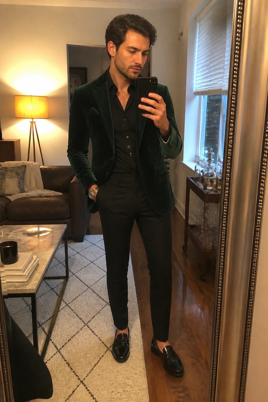 Man in green velvet blazer taking mirror selfie in living room