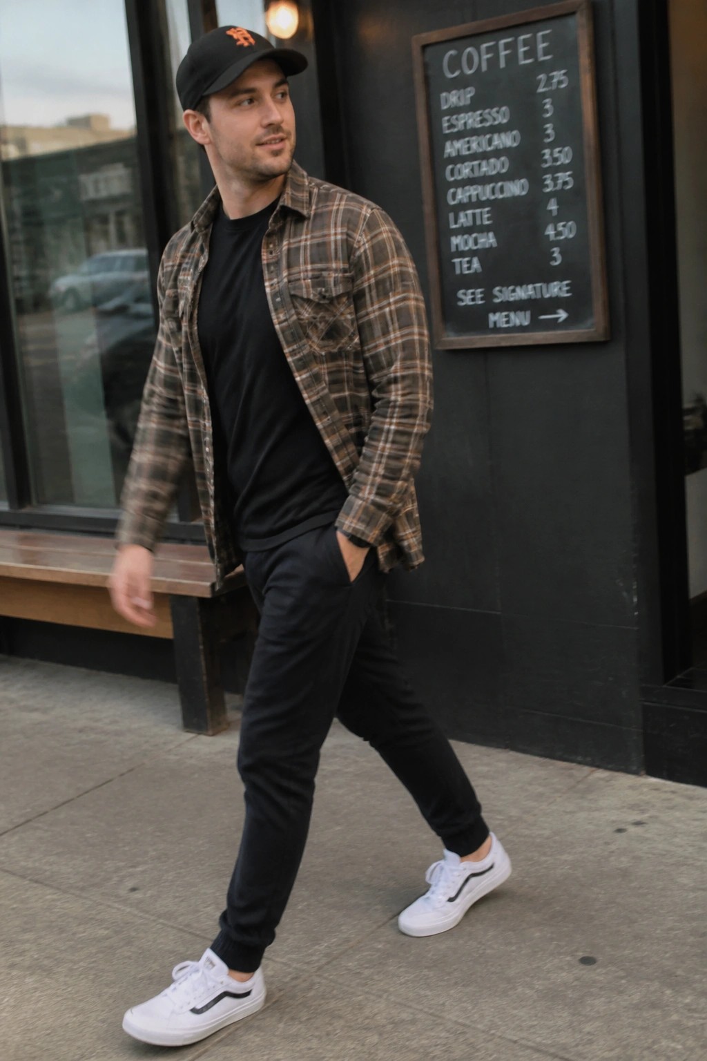Man in brown plaid shirt, black cap, and white sneakers walks past cafe menu.