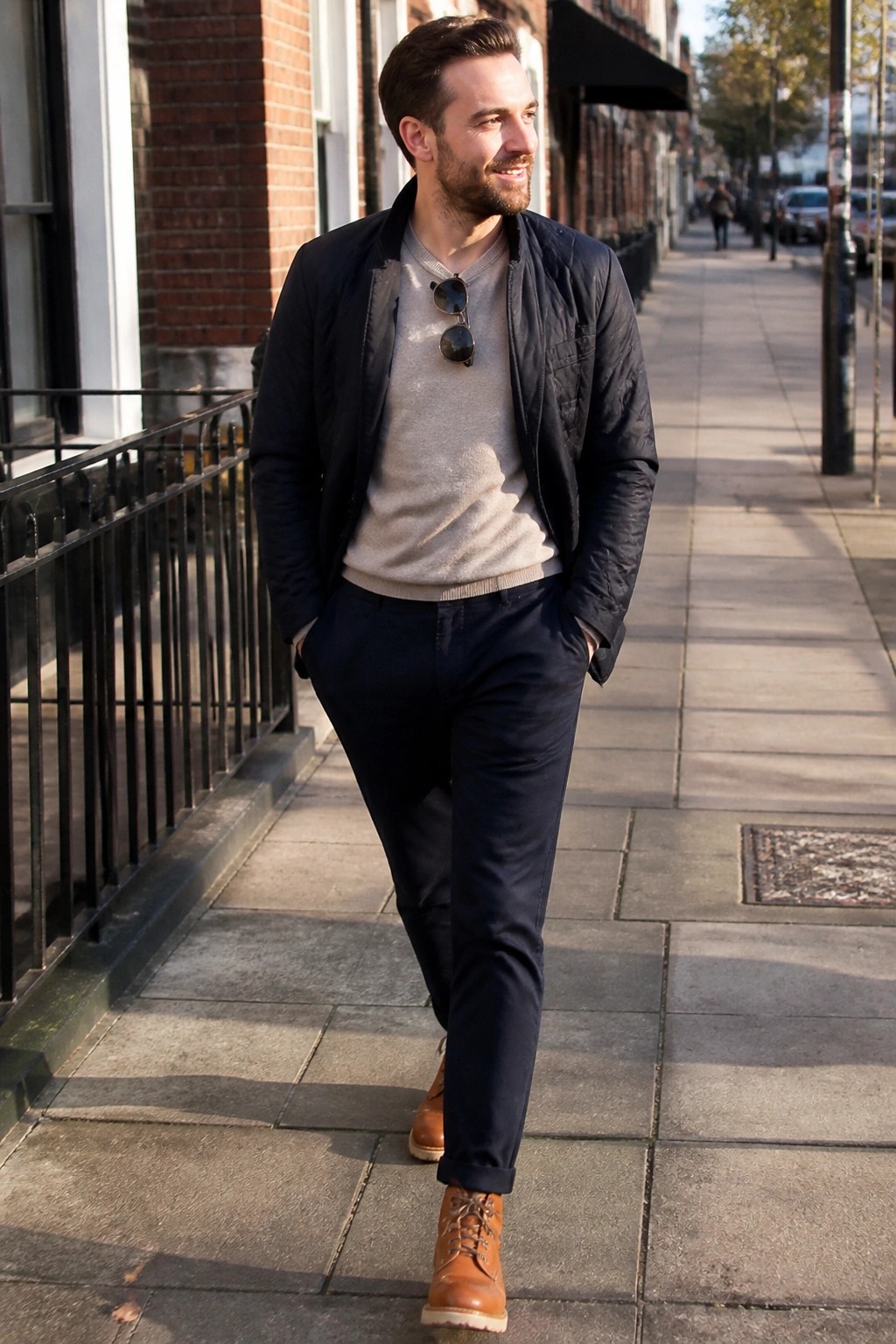 Man in navy quilted jacket over beige sweater strolling city sidewalk