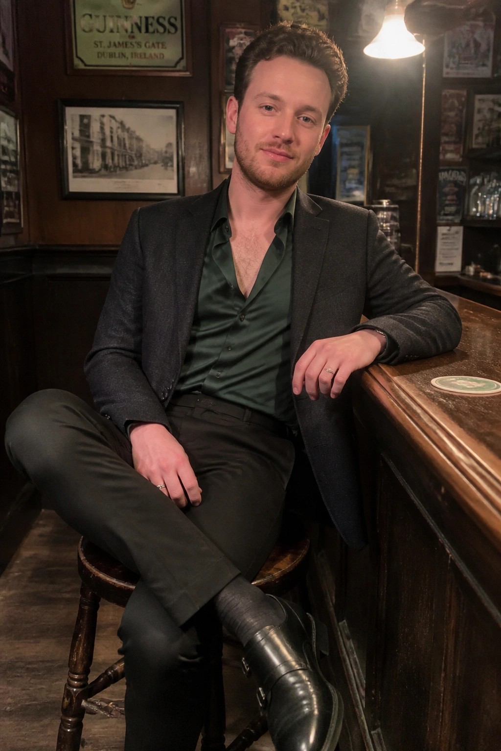 Man in gray blazer and green shirt seated at wooden pub bar