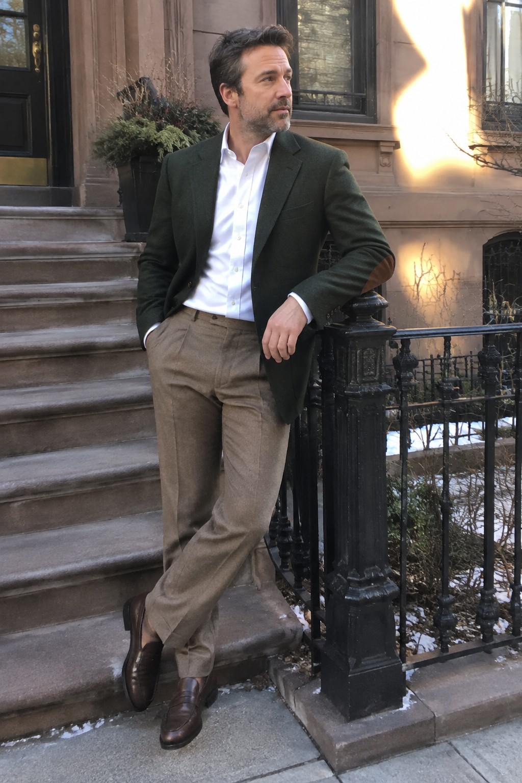 Man wearing a dark green blazer, white button-down shirt, taupe trousers, and brown leather loafers.